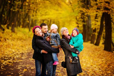 İki çocuklu aile sonbahar Park'ta yürüyordunuz