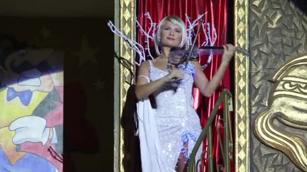 Hermoso violinista vestido de noche tocando el circo usando violín transparente . — Vídeo de stock