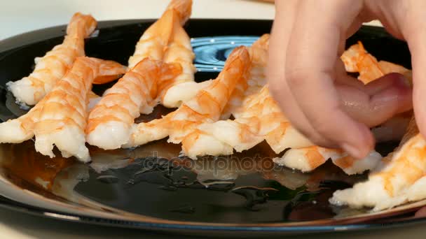 Vídeo 4k. Camarones grandes cocidos extendidos en un plato negro — Vídeos de Stock
