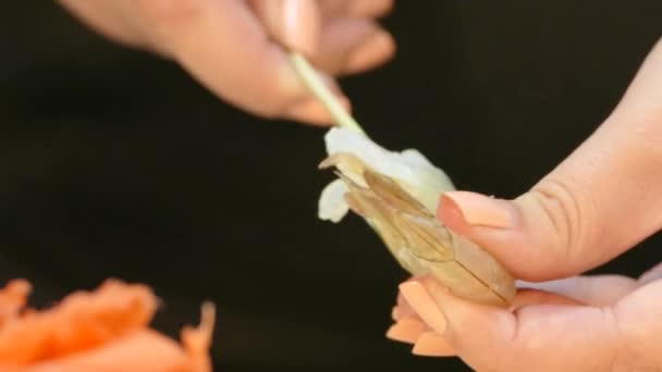 Vidéo 4k. Brochette fille crevettes crues sur les brochettes 