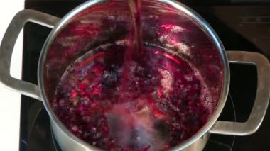 Kırmızı şarap mulled şarap yapmak için tava içine dökülür.