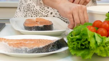Ev kadını emekli diyet yemek hazırlar. Bir çift ve sebze garnitür Izgara Alabalık.