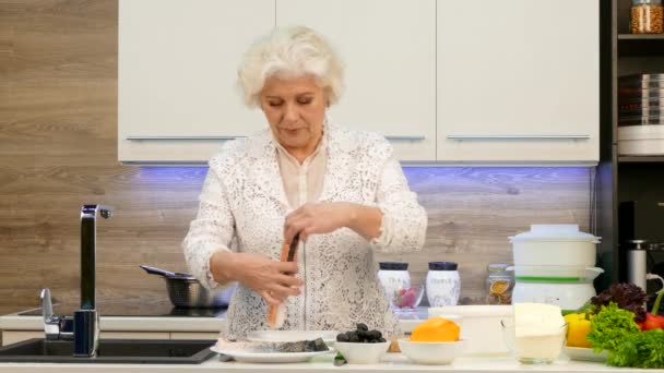 Casalinga pensionato prepara cena dietetica. Trota alla griglia su un paio di verdure e guarnire . — Video Stock