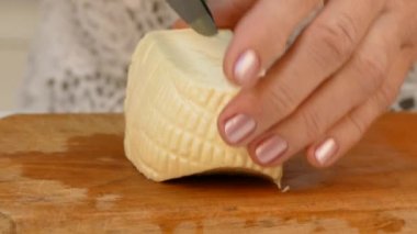 Ahşap kesme tahtası üzerinde peynir kesme erkek eller