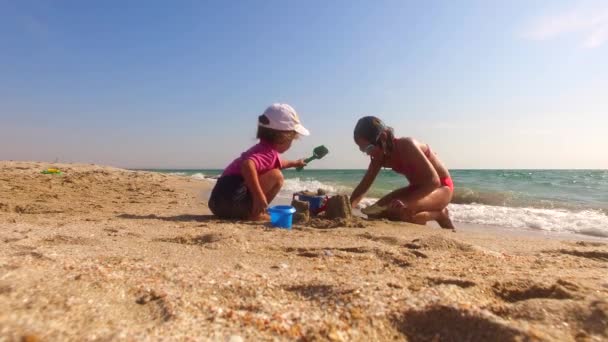 Dvě děti stavební písek hrad na pláži — Stock video