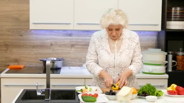 Šťastná babička dělat salát z čerstvé zeleniny — Stock video