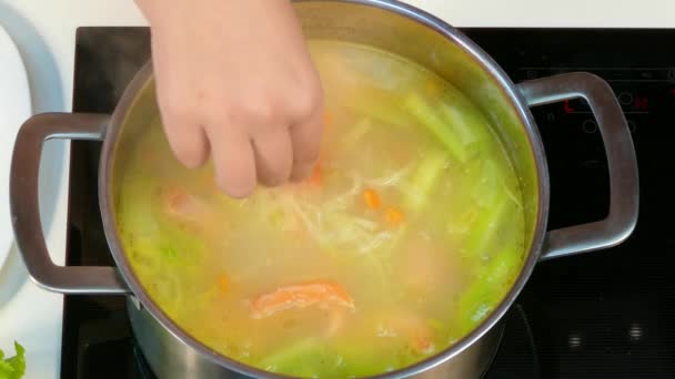 Adding fish to soup — Stock Video