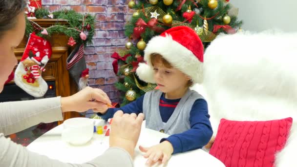Отец помогает сыну украшать рождественские украшения. — стоковое видео