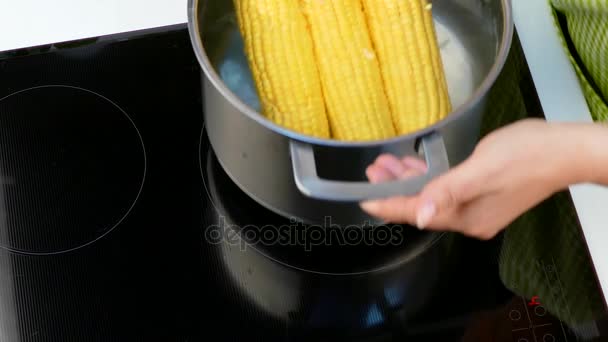 Donna mettere cuocere il mais sul fornello — Video Stock
