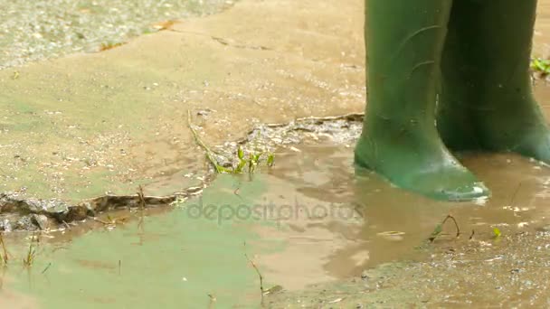 En botas de goma correr a través de los charcos — Vídeos de Stock