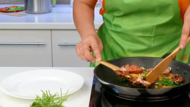 Перемещает жареные колбасы с яйцами из сковороды в тарелки — стоковое видео