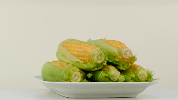 Os flocos de milho estão girando em um prato em uma mesa — Vídeo de Stock