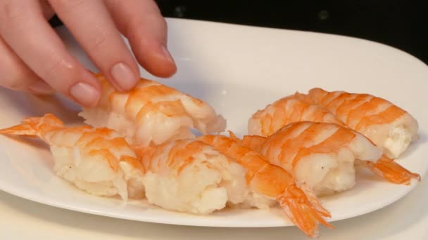 Las manos ponen sushi con camarones en un plato — Vídeo de stock