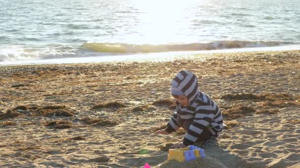 Kleine jongen maken een zandkasteel — Stockvideo