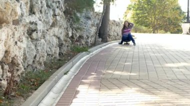 Kız bir kaykay üzerinde tepeden aşağı akıyor.