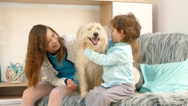 Uma menina com um menino está acariciando um cão . — Vídeo de Stock