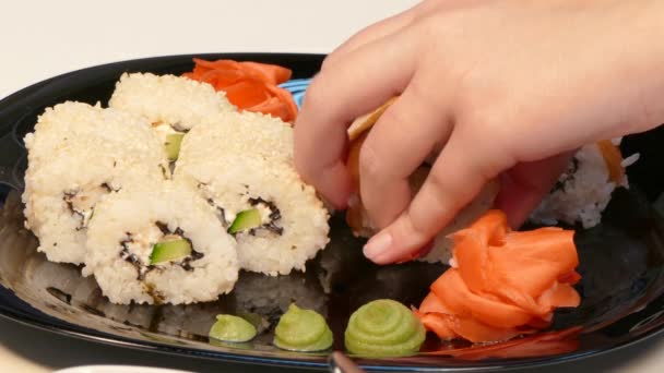 Coloque cuidadosamente los rollos de sushi en un plato . — Vídeos de Stock