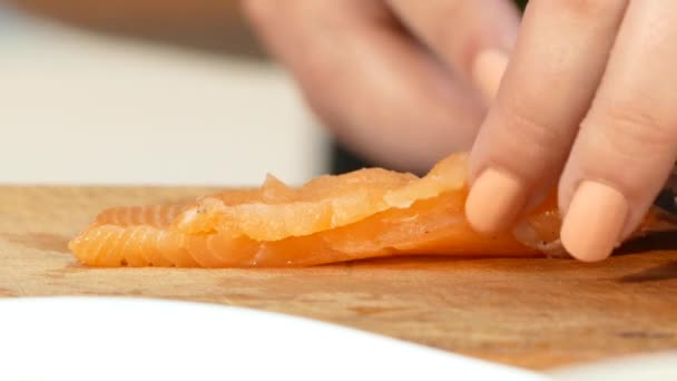 O cozinheiro corta um bife de salmão com uma faca — Vídeo de Stock