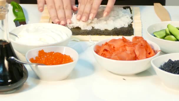 Chef hands kneading rice on the nori sheet on the kitchen table — Stock Video