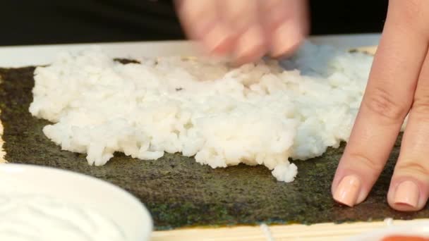 Chef mains pétrissant riz sur feuille nori — Video