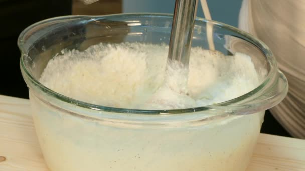 Ο μάγειρας μαστίγια η μάζα πηγμένο γάλα για τυρί με ένα μπλέντερ. — Αρχείο Βίντεο