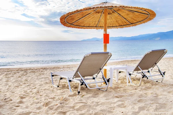 Серый соломенный зонтик на прекрасном пляже и на фоне океана — стоковое фото