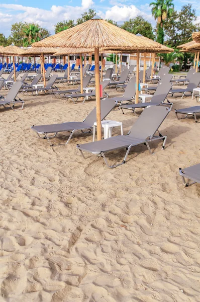 Guarda-chuva de palha cinza no belo fundo da praia — Fotografia de Stock