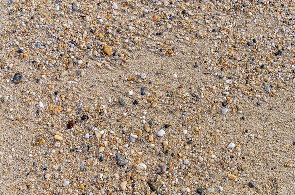 Песчаный пляж и камень на заднем плане — стоковое фото