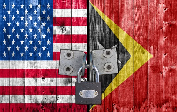 Us und east timor flag an Tür mit Vorhängeschloss — Stockfoto