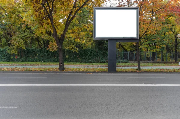 Duży czarny billboard w mieście, z tle park — Zdjęcie stockowe