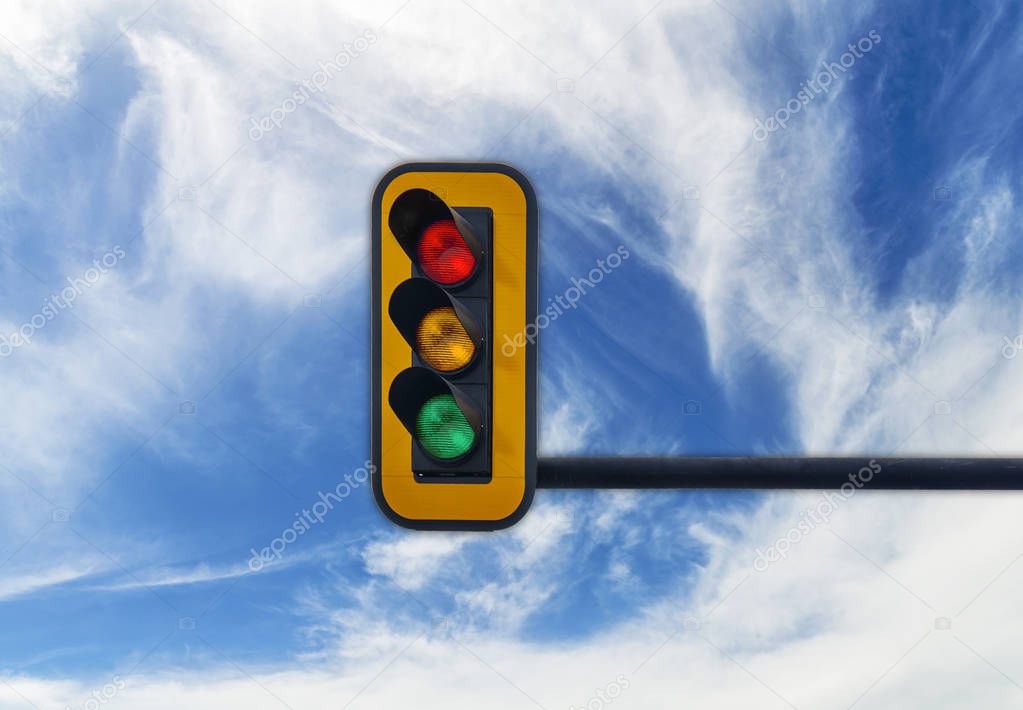 Big semaphorewith red, yellow and green light on blue cloudy sky