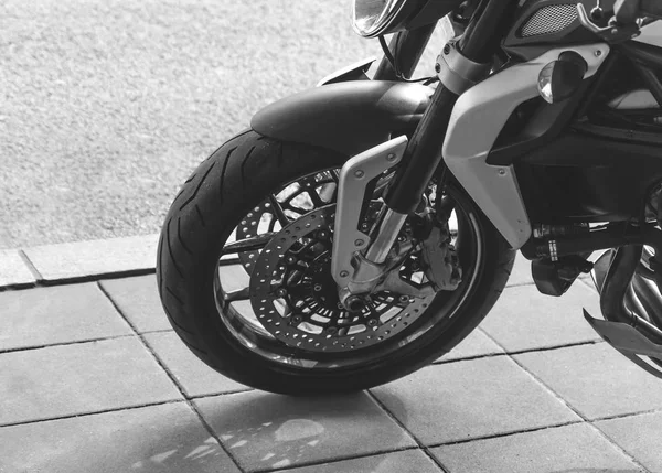 Front wheel of large motorcycle leaning on the city asphalt — Stock Photo, Image