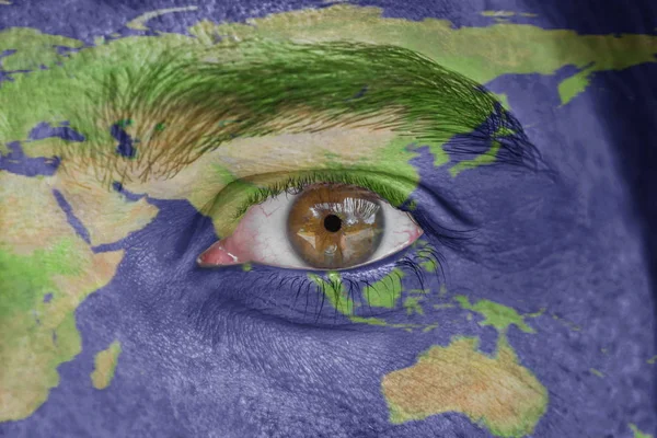Human face and eye painted with Asia space geography map