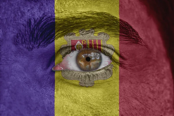 Human face and eye painted with flag of Andorra — Stock Photo, Image