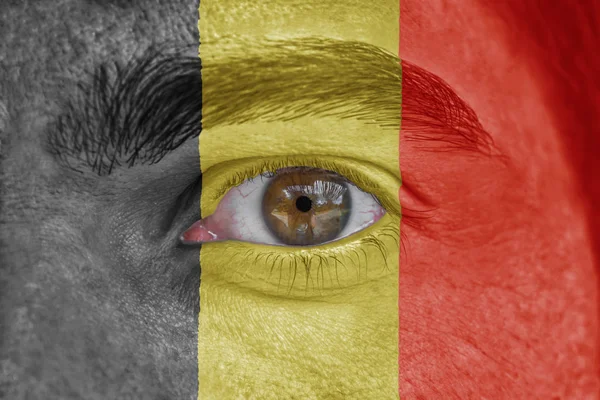 Human face and eye painted with flag of Belgium — Stock Photo, Image