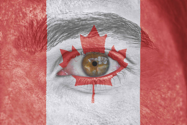 Human face and eye painted with flag of Canada