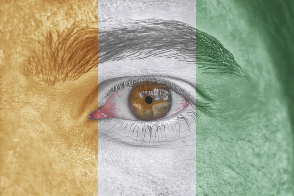 Menselijk gezicht en ogen geschilderd met vlag van Cote d'lvoire — Stockfoto