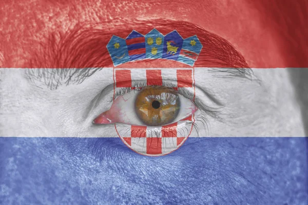 Human face and eye painted with flag of Croatia — Stock Photo, Image