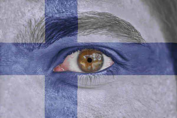 Mänskligt ansikte och ögon målade med flagga Finland — Stockfoto