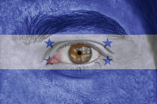 Rostro y ojo humano pintado con bandera de Honduras —  Fotos de Stock