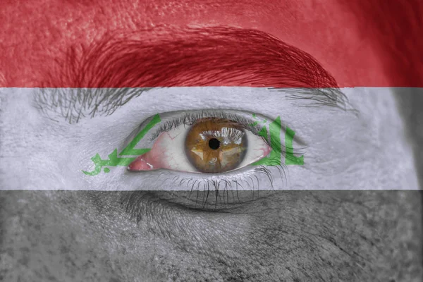 Human face and eye painted with flag of Iraqi