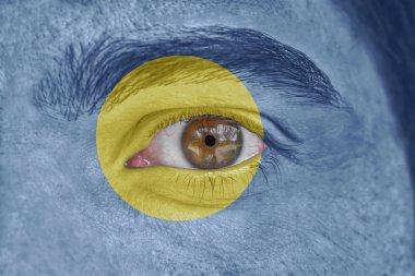 İnsan yüz ve göz Palau bayrağı ile boyalı