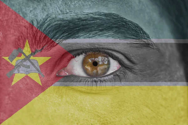 Menschliches Gesicht und Auge mit der Flagge von Mosambik bemalt — Stockfoto