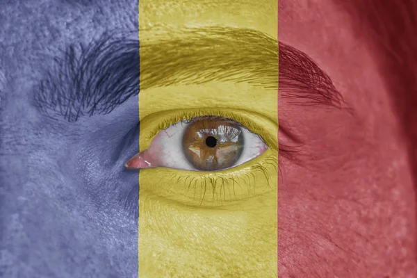 Rostro humano y ojo pintado con bandera de Rumania — Foto de Stock