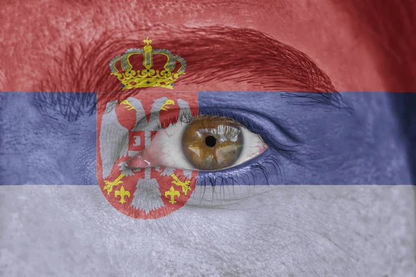 Human face and eye painted with flag of Serbia — Stock Photo, Image