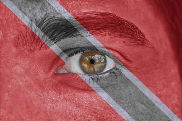 Menselijk gezicht en ogen geschilderd met vlag van Trinidad en Tobago — Stockfoto