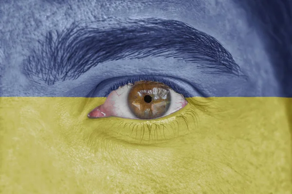 Rosto humano e olho pintado com bandeira da Ucrânia — Fotografia de Stock