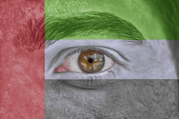 Menselijk gezicht en ogen geschilderd met vlag van Verenigde Arabische Emiraten — Stockfoto