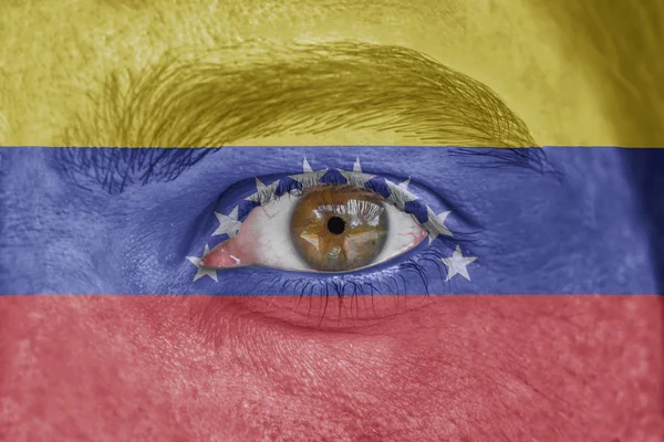 Rosto humano e olho pintado com bandeira da Venezuela — Fotografia de Stock