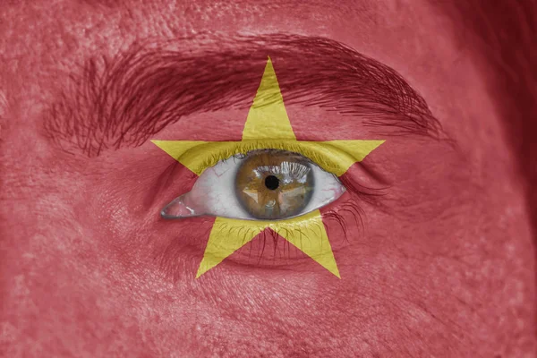 Human face and eye painted with flag of Vietnam — Stock Photo, Image